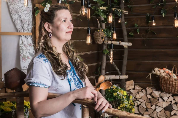 Ugly woman in national dress posing in a rustic interior