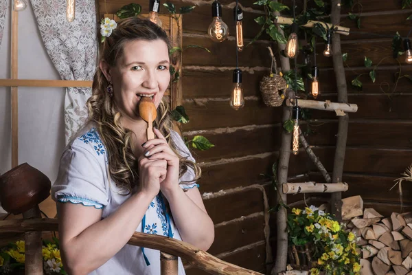 Ugly woman in national dress posing in a rustic interior