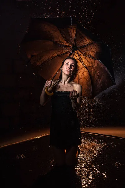 Girl in black dress with umbrella and drops of water