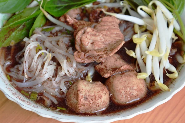 ボウルに茶色のスープに豚肉ボールを持つ細麺 — ストック写真