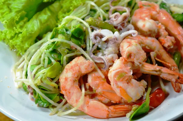 Bunga matahari tumbuh dengan udang dan cumi-cumi salad pedas di piring — Stok Foto