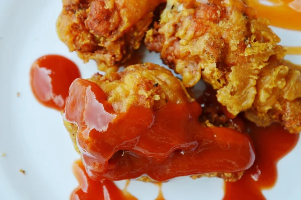 Sült csirke láb öltözködés ketchup és chili szósz fehér tányérra — Stock Fotó