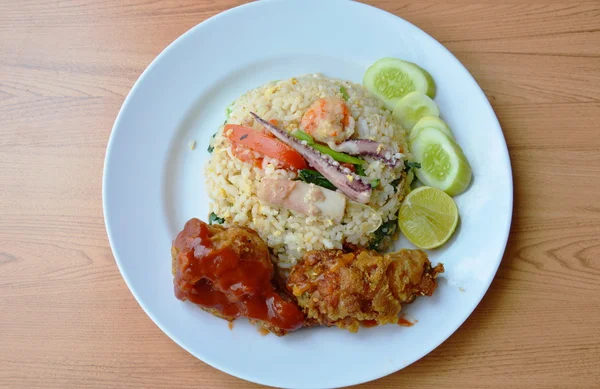 Nasi goreng dengan makanan laut campur dan ayam renyah di atas piring — Stok Foto