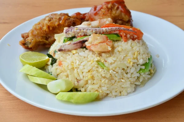 Nasi goreng dengan makanan laut campur dan ayam renyah di atas piring — Stok Foto