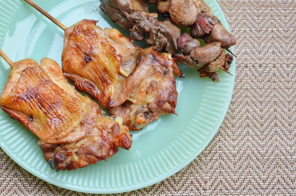 Gegrilde kip en ingewanden in houten stok op schotel — Stockfoto