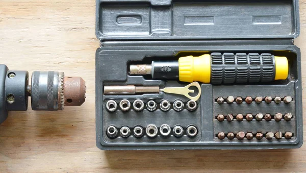 Электрическая дрель и различные размеры бита в черной пластиковой коробке — стоковое фото