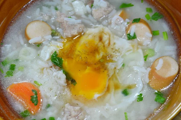 Arroz hervido con salchicha de cerdo cubriendo la yema cremosa en un tazón —  Fotos de Stock