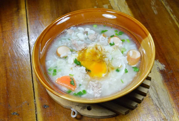 Χυλός από ρύζι με χοιρινό λουκάνικο Κορυφολόγημα κρεμώδη κρόκος στο μπολ — Φωτογραφία Αρχείου