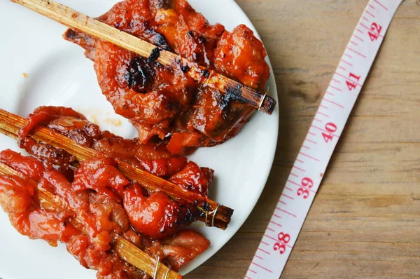 Kulit lemak ayam panggang dan pita pengukur untuk memeriksa pinggang setelah makan — Stok Foto