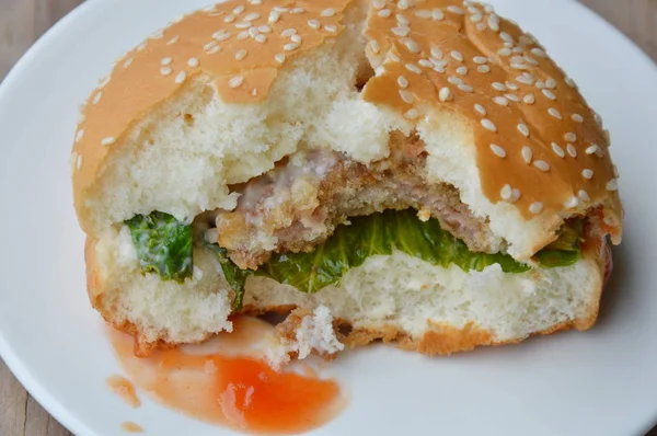 Carne de cerdo hamburguesa aderezo salsa de tomate ya morder en el plato —  Fotos de Stock