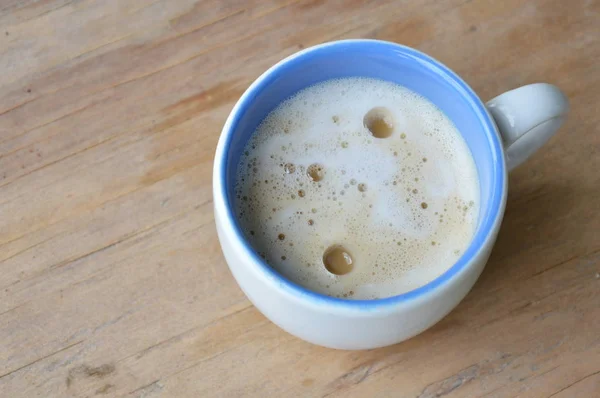 Koffie met melk schuim cup op houten tafel — Stockfoto