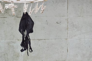 arka bahçede beyaz clothespin üzerinde asılı eski siyah sutyen