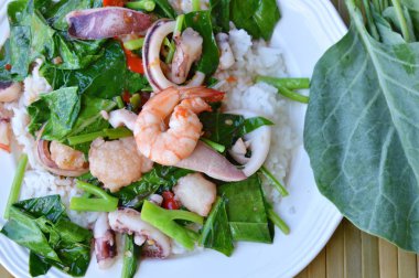 Kızarmış Çince lahana karışık deniz ürünleri ile pirinç üzerine ilave edin.