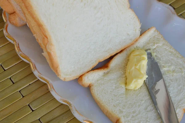 Manteiga com faca de mesa no pão — Fotografia de Stock