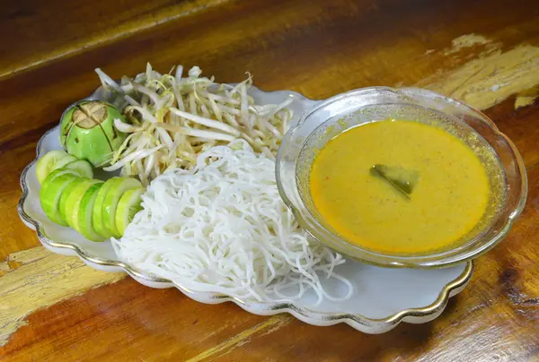 Рисова локшина і рибний каррі соус їдять з овочами на тарілці — стокове фото