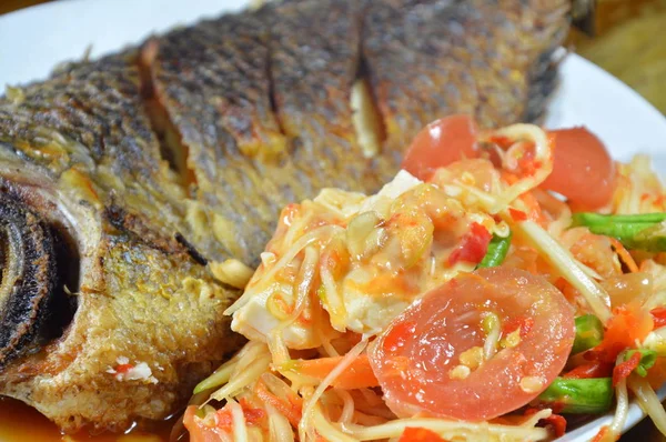 Peixe de manga frito e salada picante de mamão cobertura de ovo salgado no prato — Fotografia de Stock