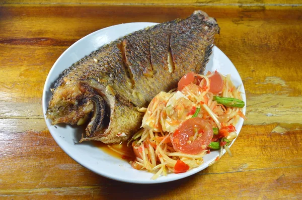 Peixe de manga frito e salada picante de mamão cobertura de ovo salgado no prato — Fotografia de Stock