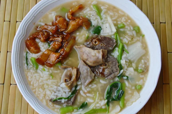 Soft boiled rice with pork entrails on bowl — Stock Photo, Image