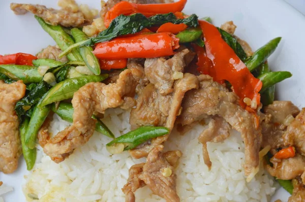 Babi goreng aduk pedas dengan daun kemangi di atas nasi — Stok Foto