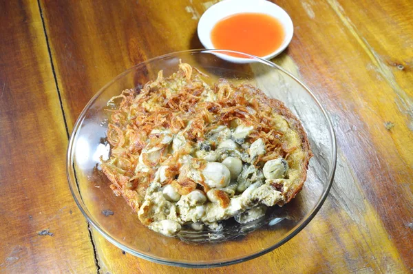 Fried egg topping oyster on plate with chili sauce — Stock Photo, Image