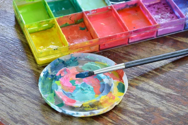 油漆刷和油色在木板上的塑料托盘 — 图库照片