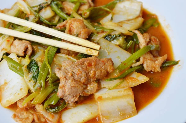 Dans une assiette, mélanger les légumes frits et le porc dans une sauce sukiyaki. — Photo