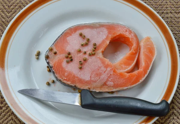 Сира заморожена перев'язка лосося перець і ніж на тарілці — стокове фото