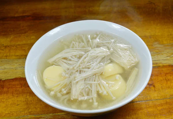 Champiñón de aguja hervido con sopa caliente de tofu de huevo en un tazón — Foto de Stock