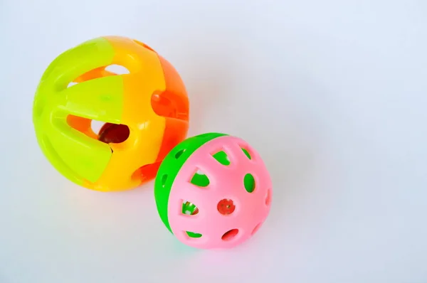 Pet colorido bola de brinquedo de plástico e sino no fundo branco — Fotografia de Stock