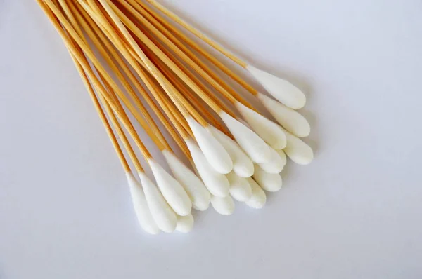 Beyaz arka plan üzerinde uzun ahşap sopa ile pamuk bud