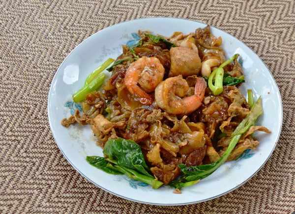 Stir fried rice noodle with seafood and black soy sauce — Stock Photo, Image