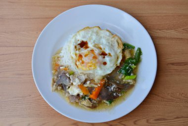 sebze ile kızarmış domuz eti et suyu sosu ilave edin ve pirinç üzerine yumurta