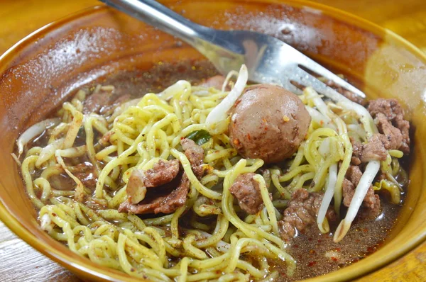 Fideos de huevo con bola de cerdo en sopa marrón en un tazón — Foto de Stock