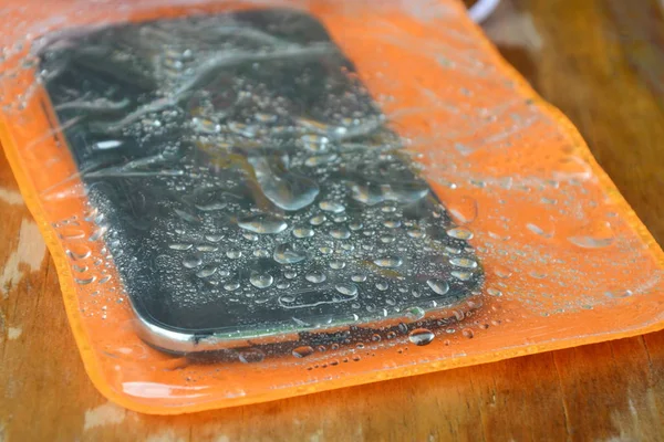Orange vattentät telefon väskan på träskiva — Stockfoto