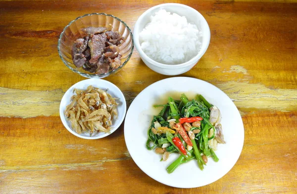 Gekookte rijst eten met gebakken ansjovis en morning glory op tafel — Stockfoto