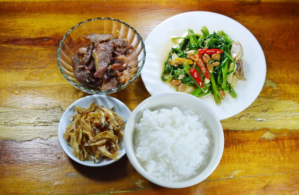 Nasi rebus makan dengan ikan teri goreng dan pagi kemuliaan di atas meja — Stok Foto