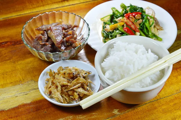 Gekookte rijst eten met gebakken ansjovis en morning glory op tafel — Stockfoto