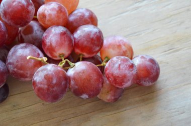 ahşap tahta üzerinde kırmızı üzüm