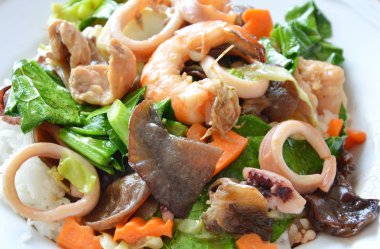 Deniz ürünleri ve domuz kızarmış karışık sebze üzerinde pirinç ilave edin.