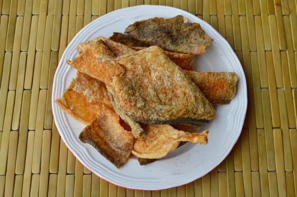 Pele de peixe frito crocante com tempero em prato — Fotografia de Stock