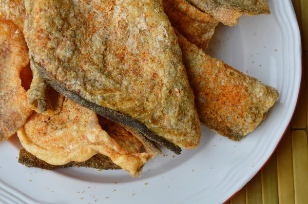 Piel de pescado frito crujiente con condimento en el plato — Foto de Stock