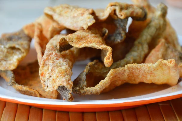 Piel de pescado frito crujiente con condimento en el plato —  Fotos de Stock