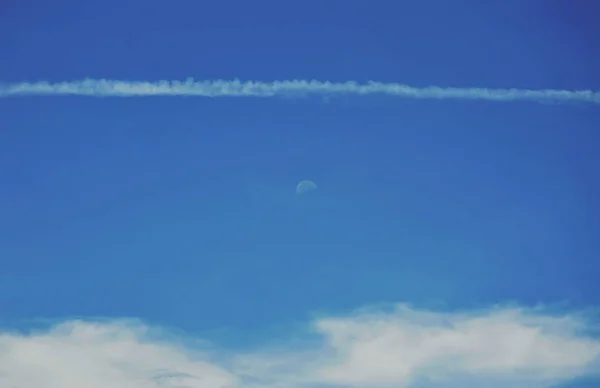 Uçakta gündüz gökyüzünde ay ve yoğunlaşma izi — Stok fotoğraf