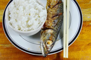 Kızarmış Pasifik uskumru ile sade pilav yemek