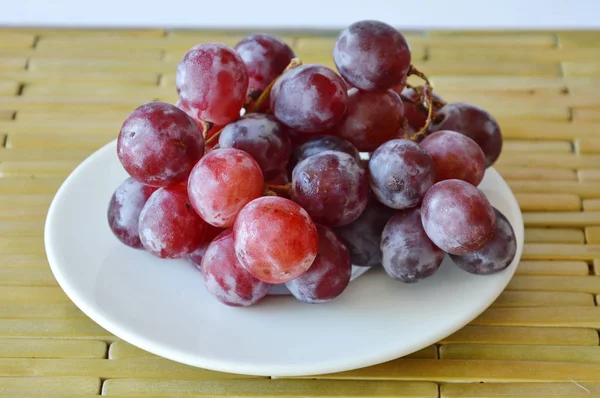 Uva roja en el plato — Foto de Stock