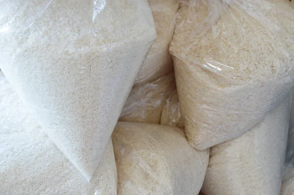 Thajská jasmínová rýže paddy, balení v plastovém sáčku punčochu na sklad — Stock fotografie