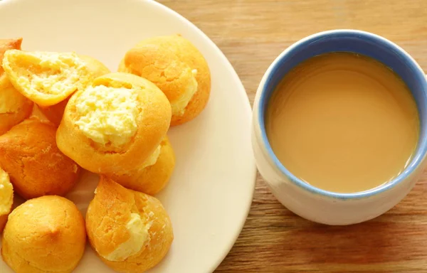 Vanilla krim puff pada piring dan cangkir kopi — Stok Foto