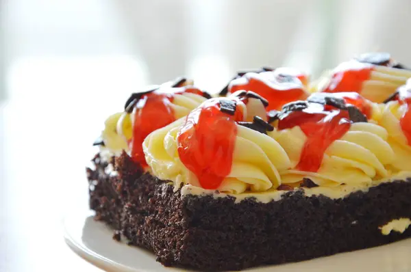 Crema de cobertura de pastel de chocolate y salsa de fresa aderezo en el plato — Foto de Stock