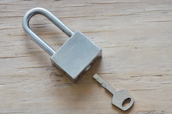Master key unlocked on wooden board — Stock Photo, Image