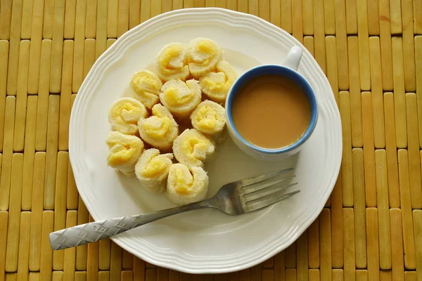Leipää täynnä voita roll syödä kahvia lautasella — kuvapankkivalokuva
